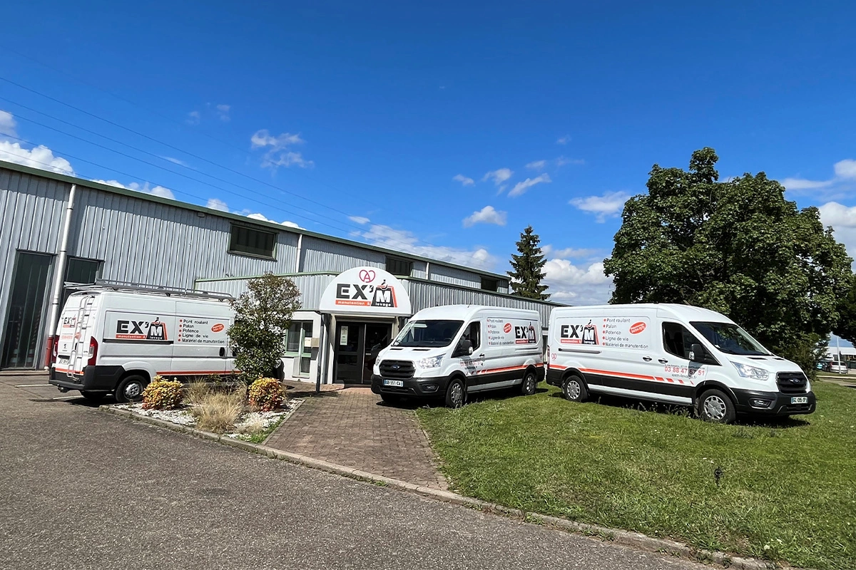 Photographie de 3 camionnettes EX'M Levage devant les locaux de l'entreprise